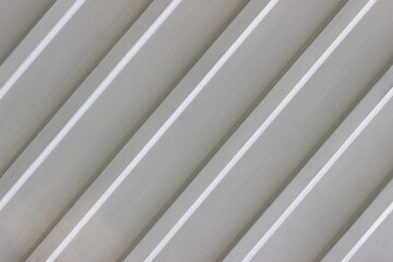 Metal wall with diagonal lines. White profiled metal sheet.