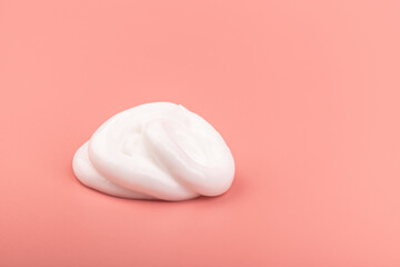 Fototapeta na wymiar White cosmetic cream smear isolated on pink background. Skincare product creamy texture.