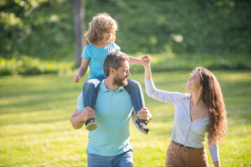 Foster care. Foster parents and son. Mother and child riding piggy back on father. Adoptive family