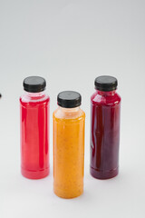 Plastic bottles of cold-pressed unprocessed fruit and vegetable juices, light gray table. Body cleanse, fast concept. Minimalist food photography. Copy Space. High quality photo