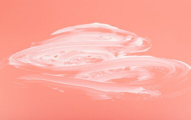 White cosmetic cream smear isolated on pink background. Skincare product creamy texture.