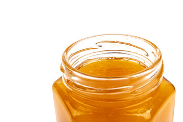 Glass jar full of sweet honey isolated on white background
