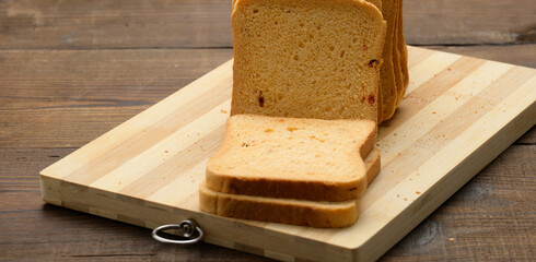 sliced white wheat flour bread on a wooden board. Sandwich bread