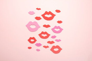 Lips and kiss shape on pink background.