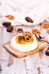 Vanilla panna cotta with caramel on wooden rustic table