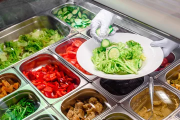 Fotobehang Showcase salad bar with an assortment of ingredients for healthy and dietary food. Salad making process. High quality photo © Kirill