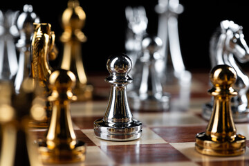 Gold and silver chess figures placed on chessboard