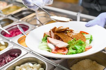 Showcase salad bar with an assortment of ingredients for healthy and dietary food. Salad making process. High quality photo