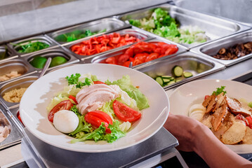 Showcase salad bar with an assortment of ingredients for healthy and dietary food. Salad making process. High quality photo