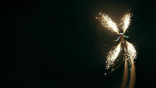 The flyboarder gave night fireworks over the sea.
