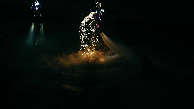 The flyboarder gave night fireworks over the sea.