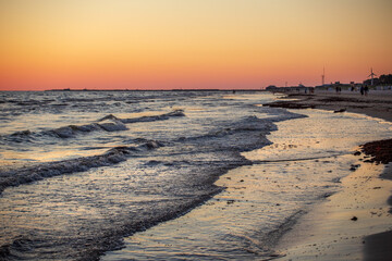 Gorgeous sunset in the Baltic Sea. At the horizon the yacht sails and the ship is about to enter the port.