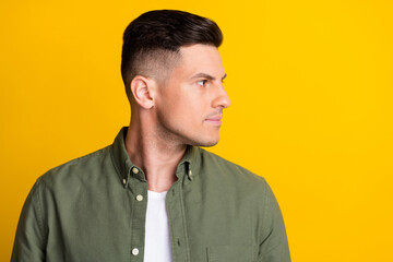 Fototapeta premium Side profile photo portrait man confident looking copyspace in green shirt isolated vivid yellow color background
