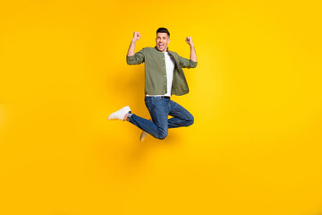 Fototapeta na wymiar Full length body size photo guy jumping up gesturing like winner isolated vibrant yellow color background