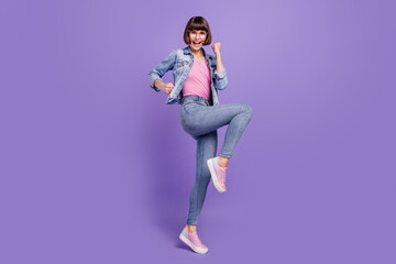 Full body photo of millennial brunette lady wear spectacles jeans shirt sneakers isolated on purple background