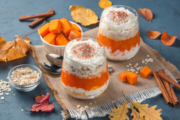 Pumpkin dessert with cream and cereals on a dark siam background. Autumn dessert. Side view, horizontal.