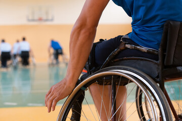 Obraz premium Close up photo of wheelchairs and handicapped war veterans playing basketball on the court