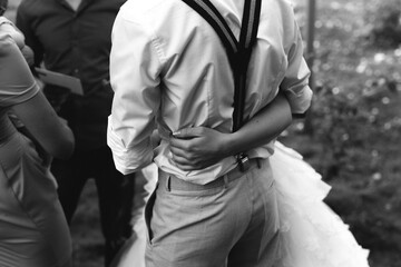 hugs of a young couple wedding dress suspenders black and white photo