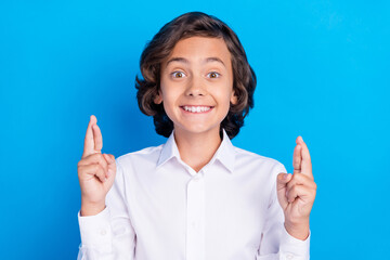 Photo of sweet charming school boy wear formal outfit smiling fingers crossed isolated blue color background