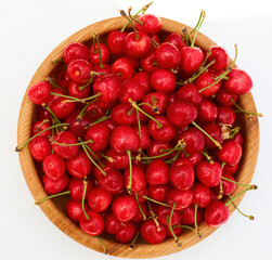 Sweet fresh cherries in wooden bowl on white background 