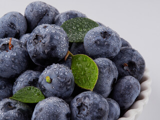 Blueberry fruit top view isolated on a white background, flat lay overhead layout with mint leaf, healthy design concept.