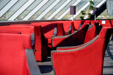 Luxurious observation or panorama lounge with floor to ceiling windows and red velvet arm chairs...