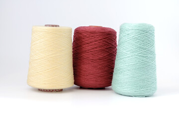 Multicolors bobbins of wool yarn for hand and machine knitting on a white background