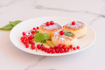 Cottage cheese pancakes, sweet curd fritters with red currant berries, syrniki on breakfast table