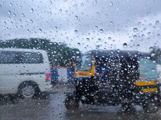 Rain drop on the car glass. Road TRAFFIC view through car window with rain drops, monsoon season in...