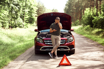 Front view of man using phone for help on the road