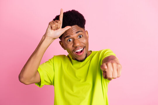 Photo of young african guy rude mocking bully point indicate finger you isolated over pink color background