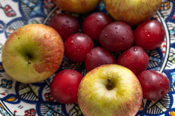 plum, cherry, apple, fruits on color plate