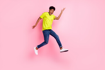 Fototapeta na wymiar Full length profile side photo of young cheerful afro guy happy positive smile jump up isolated over pink color background