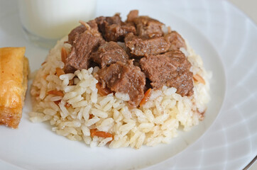 A traditional Kurban Bayram meal in Turkey. Braised meat served with rice, Baklava and Ayran drink.