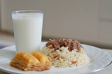 A traditional Kurban Bayram meal in Turkey. Braised meat served with rice, Baklava and Ayran drink.