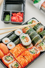 Young woman eating sushi at home. Home food delivery concept. Japan food. Top view. Space for text. High quality photo