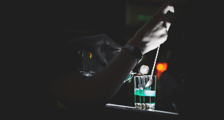 woman bartender hand making collection of colorful shots. Set of cocktails at the bar
