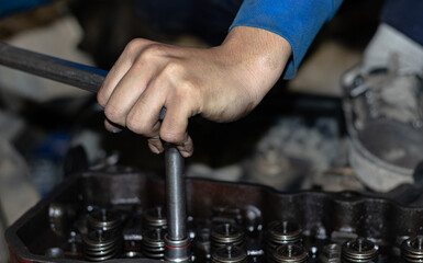 The mechanic is checking the engine.