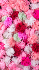 knitted wool flowers abstract, colorful woven yarn background texture, backdrop or wallpaper closeup