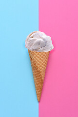 A Chocolate Chip Ice Cream Cone on a blue and pink background. Flat lay minimalist styling.