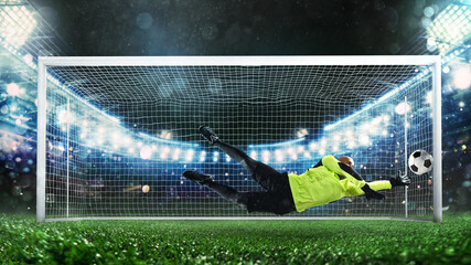Soccer goalkeeper, in fluorescent uniform, that makes a great save and avoids a goal during a match...