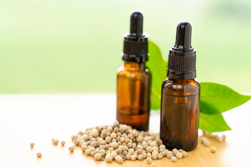 A bottle of coriander essential oil with coriander seeds, natural background