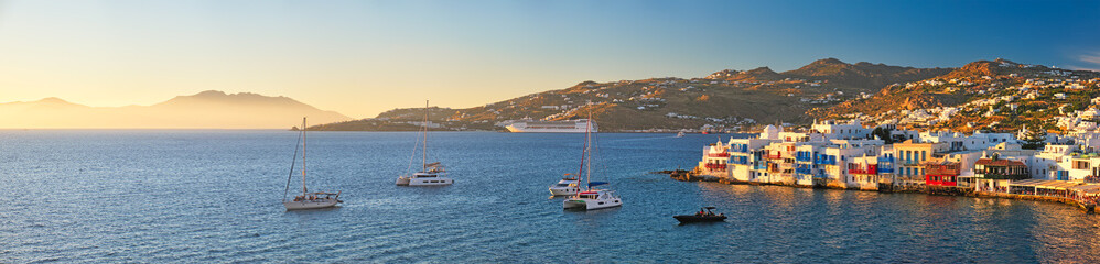 Fototapeta na wymiar Sunset in Mykonos, Greece, with cruise ship and yachts in the harbor