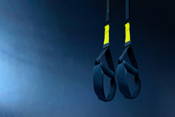 Loops for fitness in the gym. professional simulator. Fitness club background. Template for posting your texts and stories. Empty gym in the sun. Fitness studio interior with white floor and gray wall