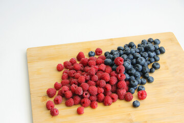 raspberries and blueberries on wooden table