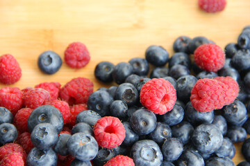 raspberries and blueberries on wooden table