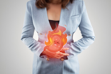 Acid reflux disease symptoms or heartburn, illustration stomach burn on woman's body against gray...