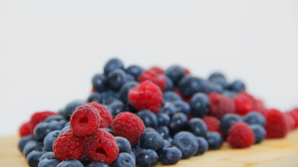fresh raspberries and blueberries on a white background close-up