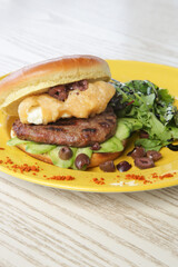Burger served with arugula and olives on side