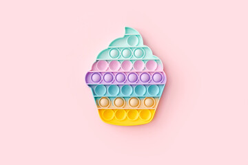 Popit toy in the form of a cupcake on a pink background, top view - obrazy, fototapety, plakaty